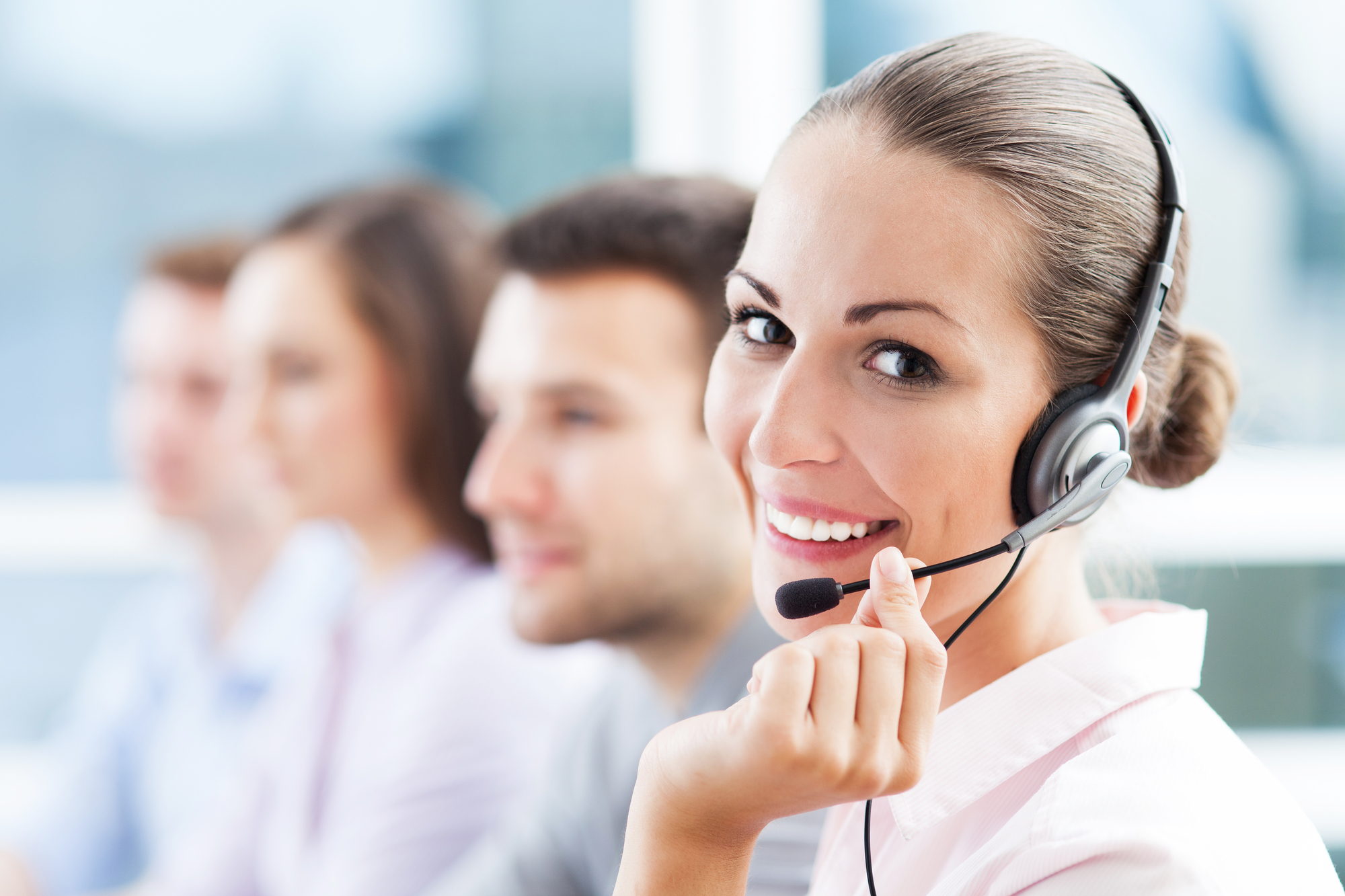una mujer sonriente atiende al cliente por telefono